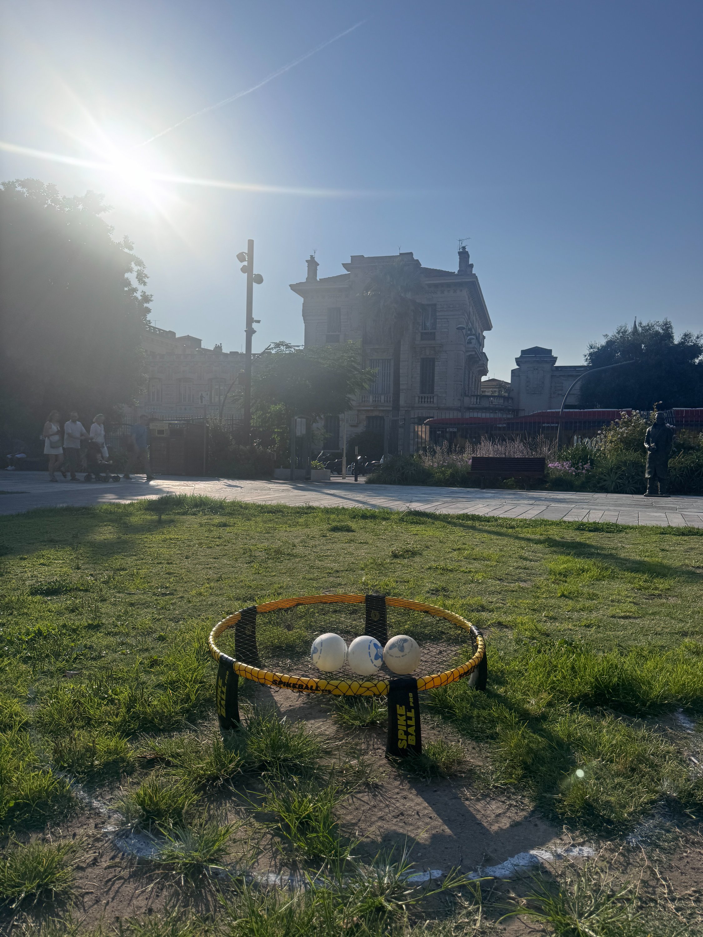 Session de roundnet au Jardin Albert 1er à Nice, quatre joueurs autour du filet avec la tour de l'horloge en arrière-plan